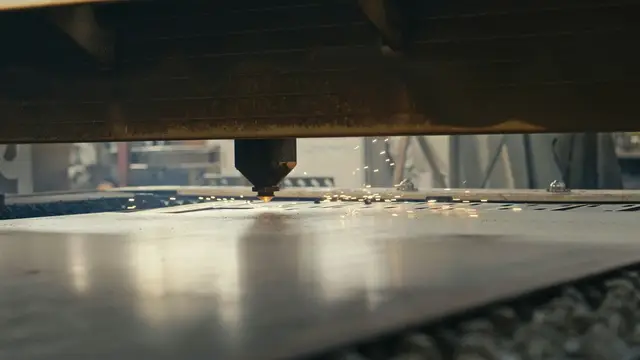 Cabeçote de máquina laser posicionado sobre chapa metálica